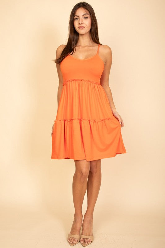 Woman wearing an orange dress against a beige background