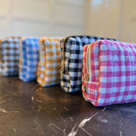 Four checkered pouches in different patterns on a marble surface