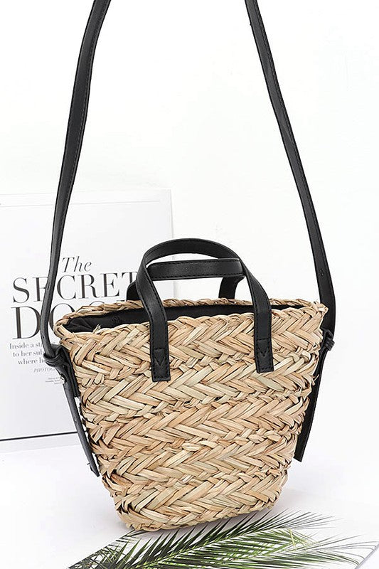 Woven handbag with black handles on a white background