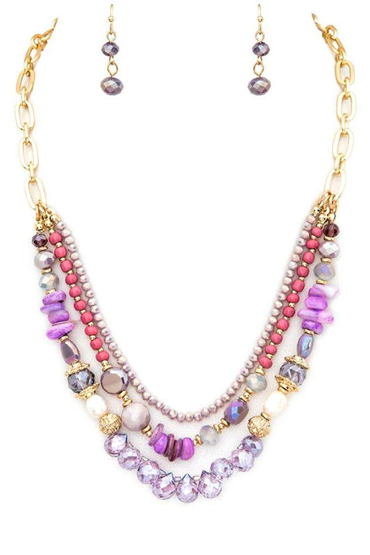 Multistrand beaded necklace with pink, purple, and gold accents on a white background