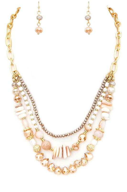 Multistrand beaded necklace with gold chain on a white background