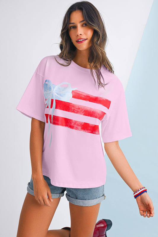Woman wearing a pink t-shirt with a graphic design on a light gray background