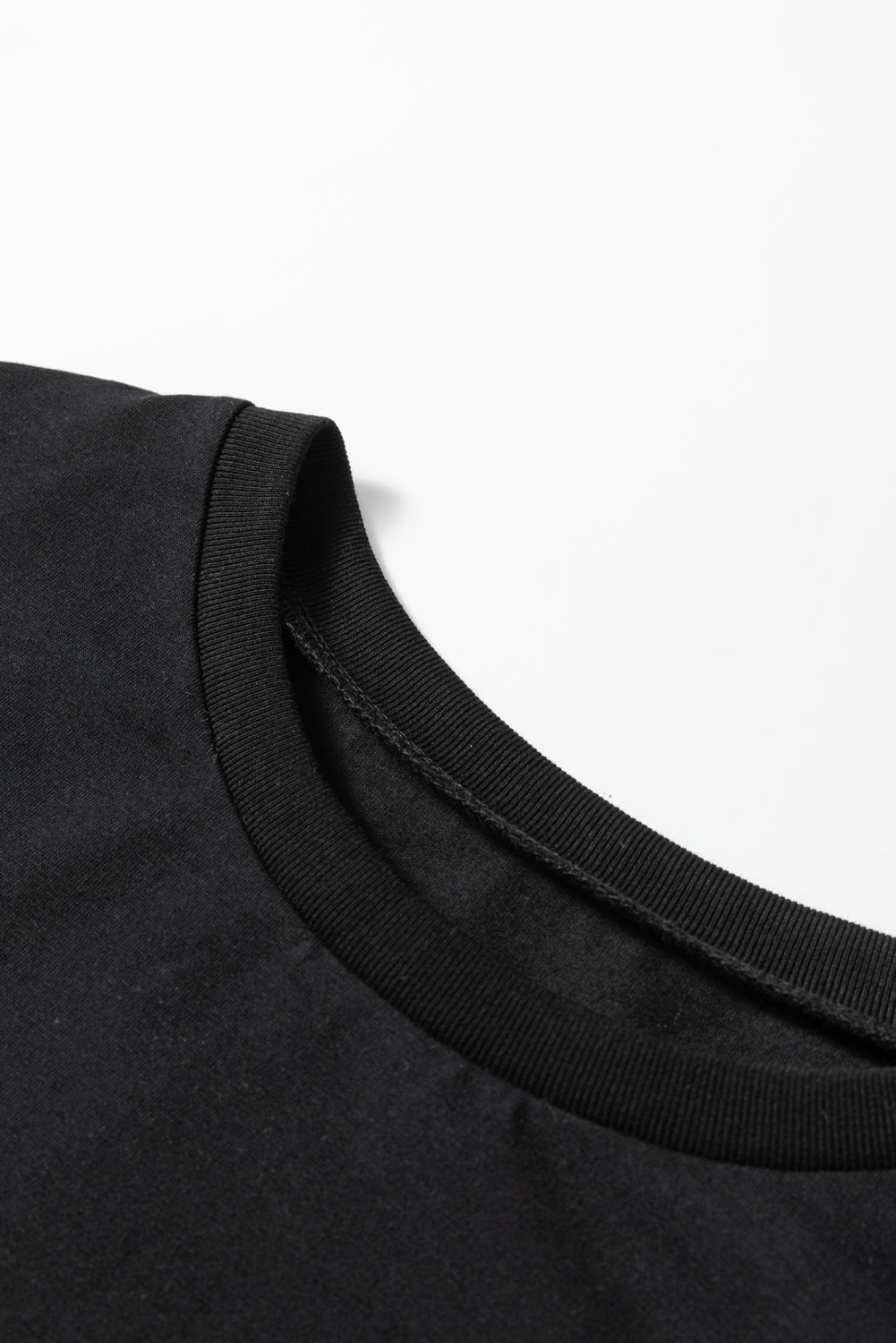 Close-up of a black t-shirt collar on a white background