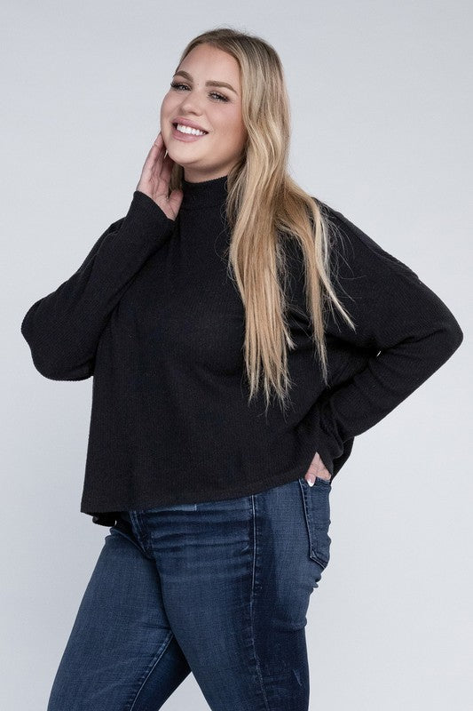 Woman wearing a black sweater and blue jeans against a white background