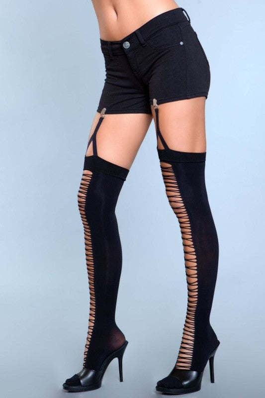 Black thigh-high stockings with cut-out side panels worn by a person on a light blue background
