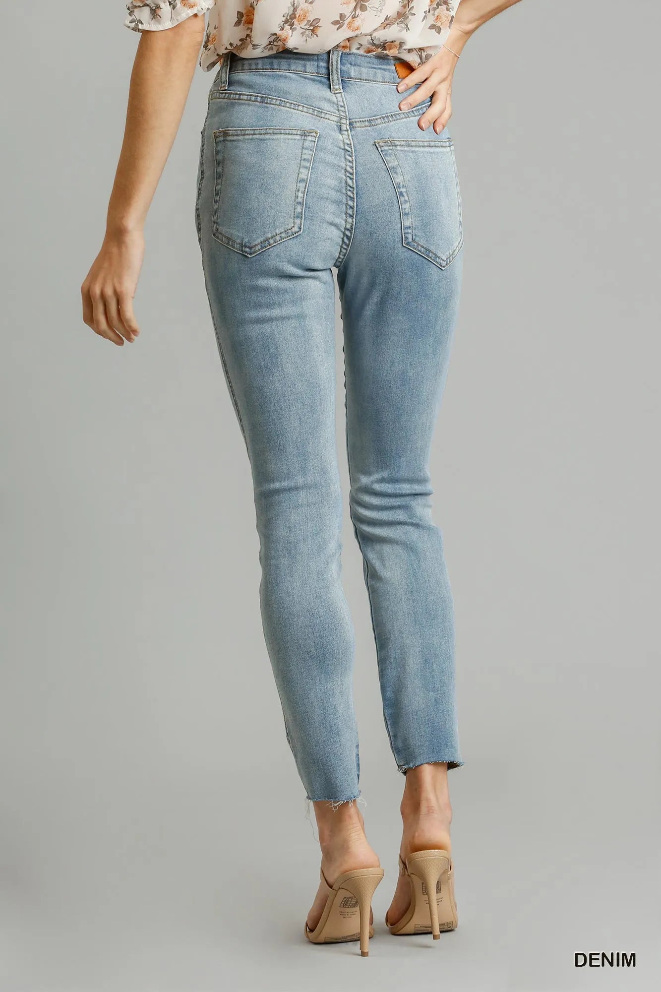 Light blue jeans worn by a person on a gray background
