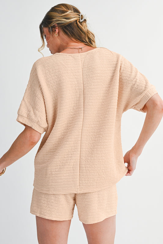 Woman wearing a beige textured outfit on a plain background