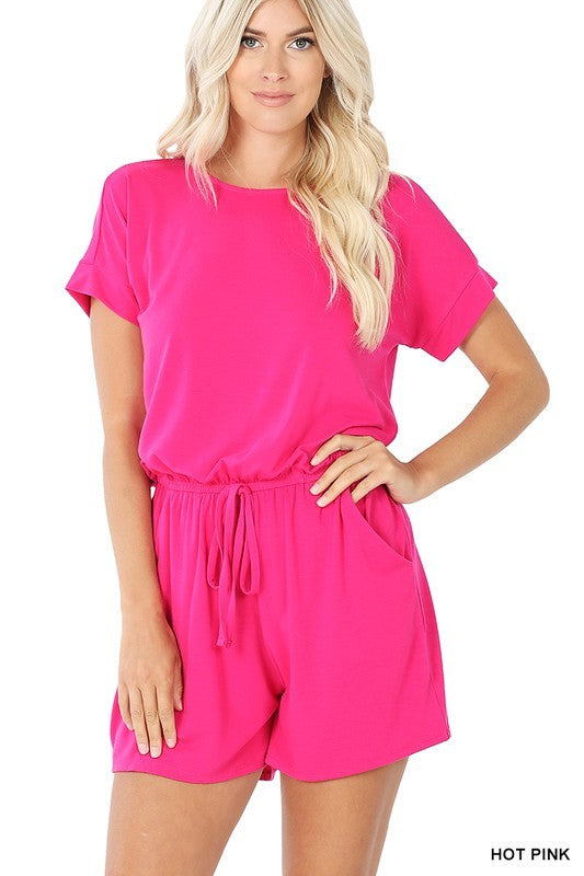 Woman wearing a bright pink romper on a white background
