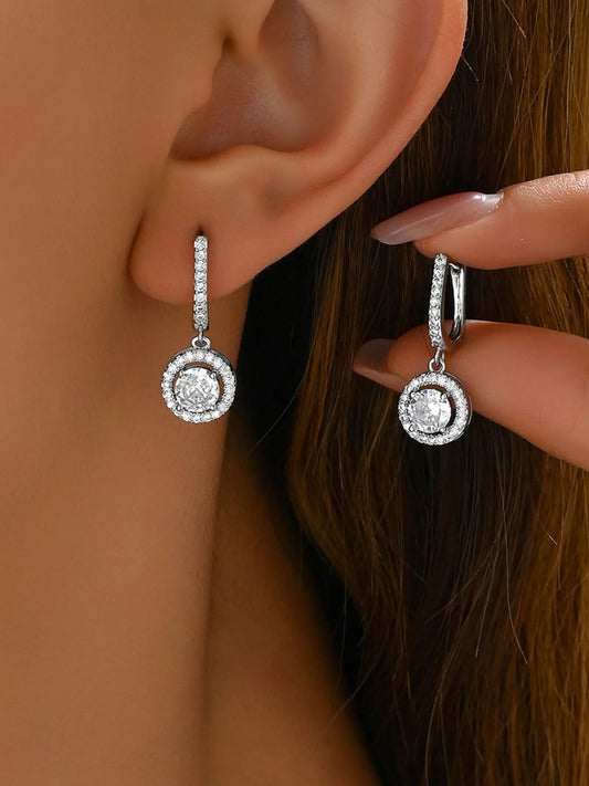 Close-up of a woman wearing silver hoop earrings with a blurred background