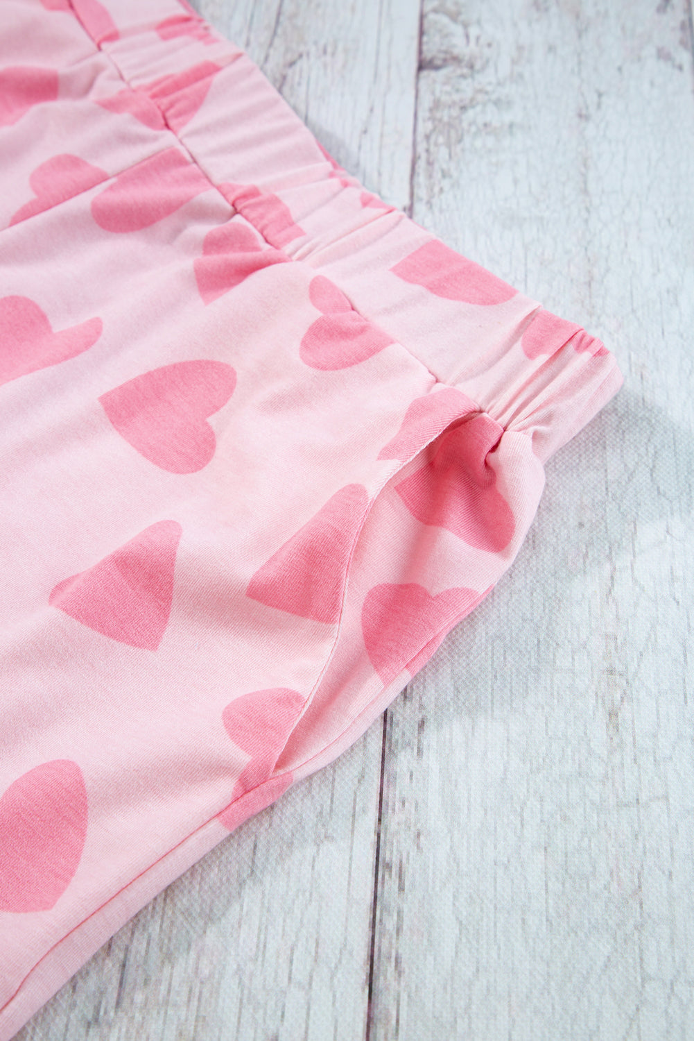 Pink shorts with heart pattern on a light wooden surface
