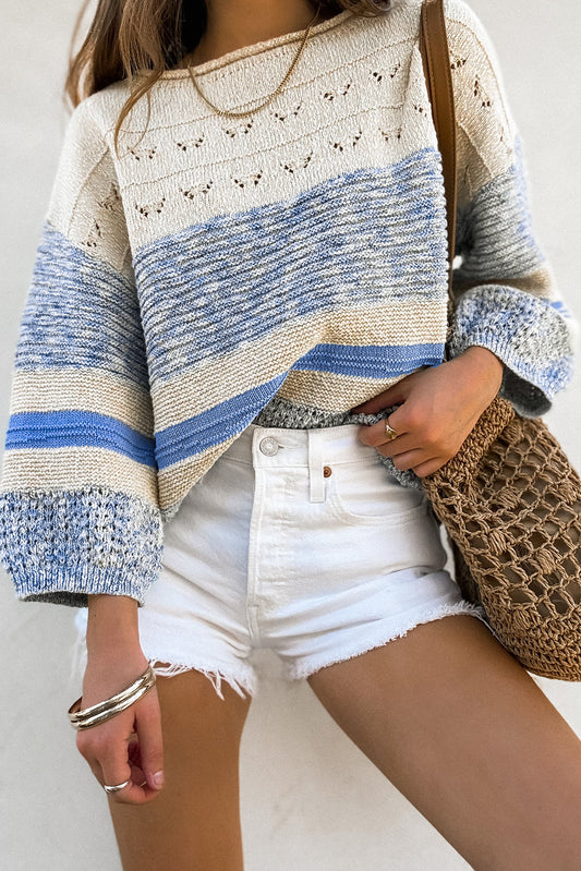 Person wearing a striped sweater and white shorts with a brown bag.