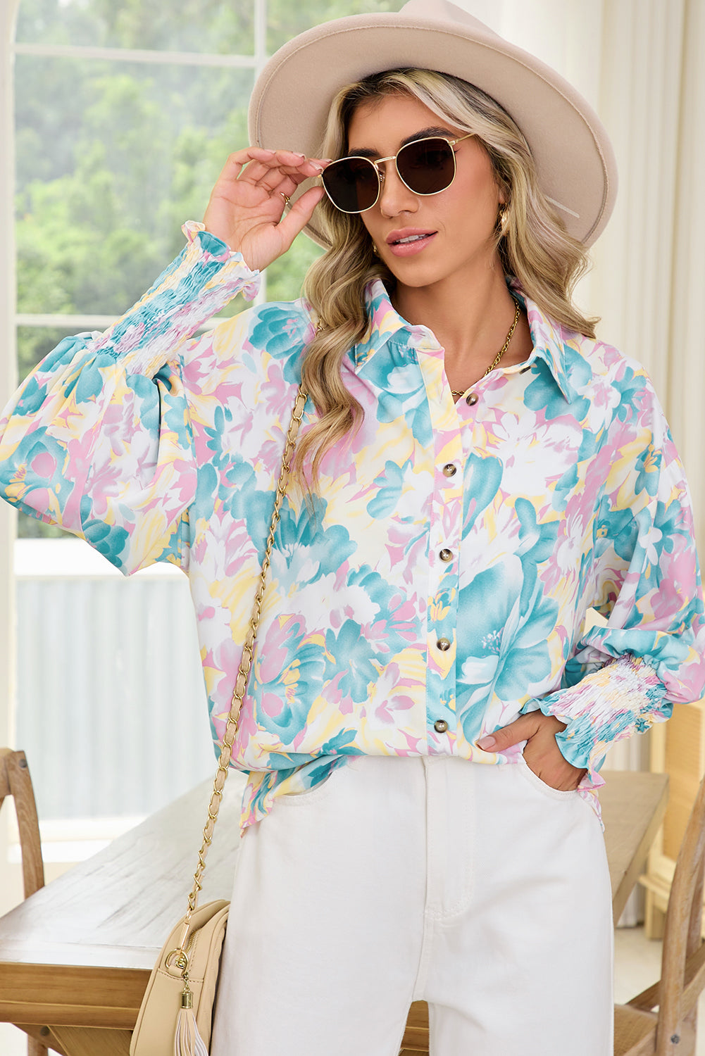 Woman wearing a colorful floral shirt and white pants in an outdoor setting