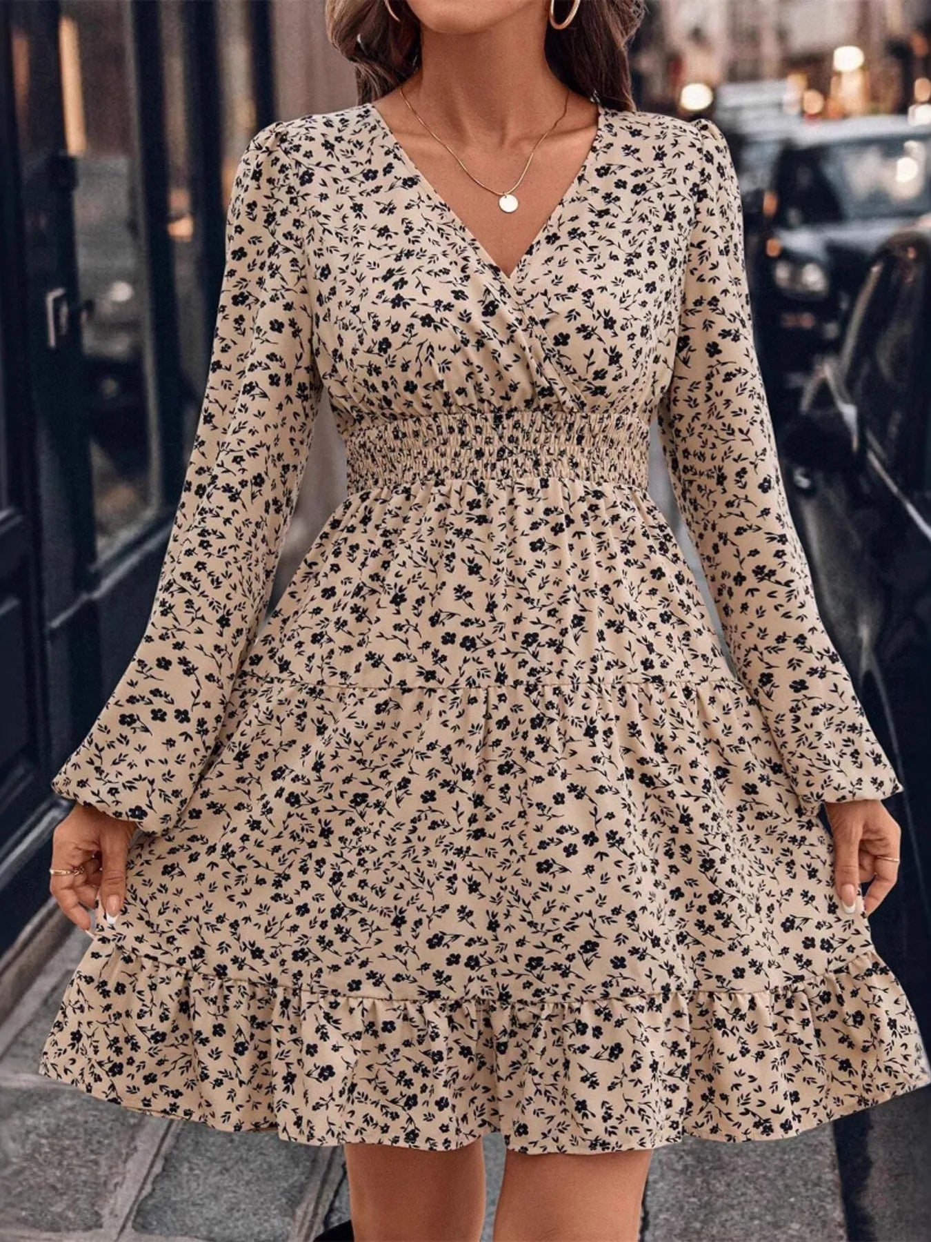 Woman wearing a floral dress on a city street.