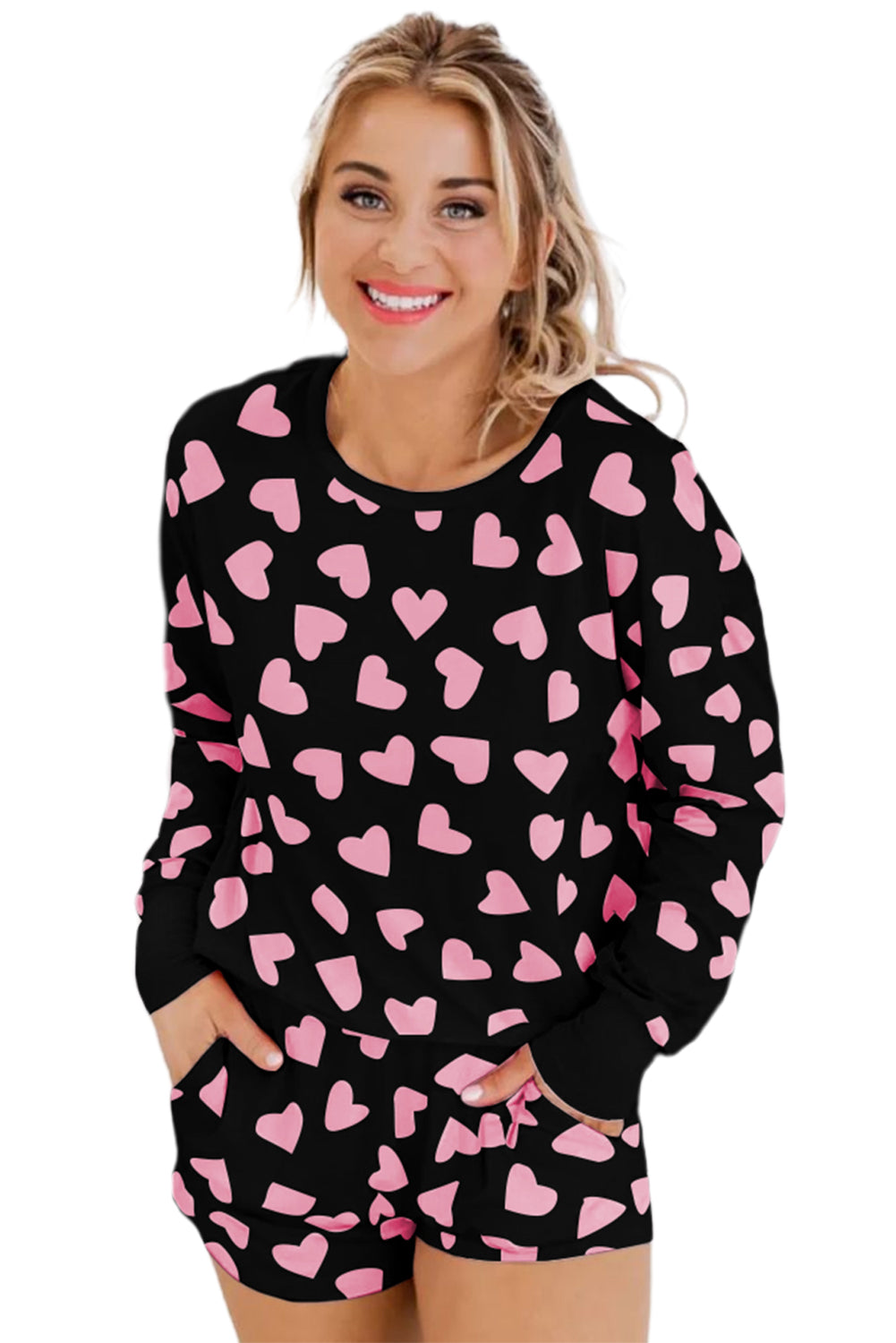 Woman wearing a black outfit with pink heart patterns on a white background