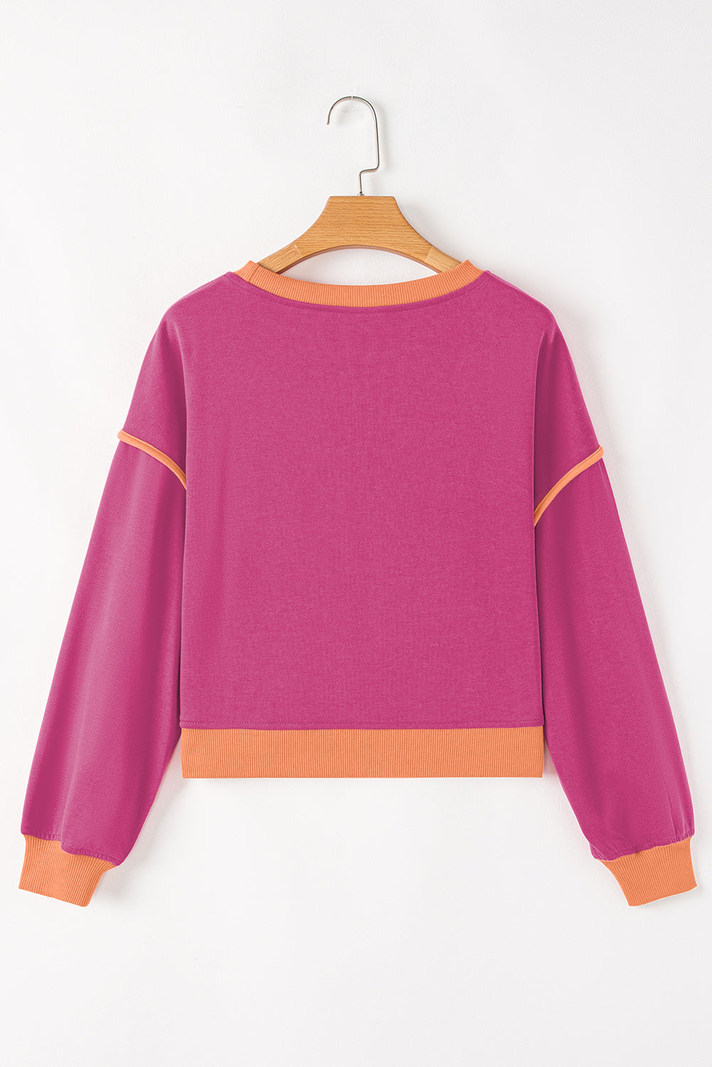 Purple sweatshirt with orange accents on a hanger against a white background