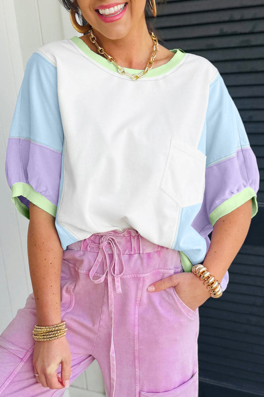 Person wearing a colorful top and pink pants with a white background