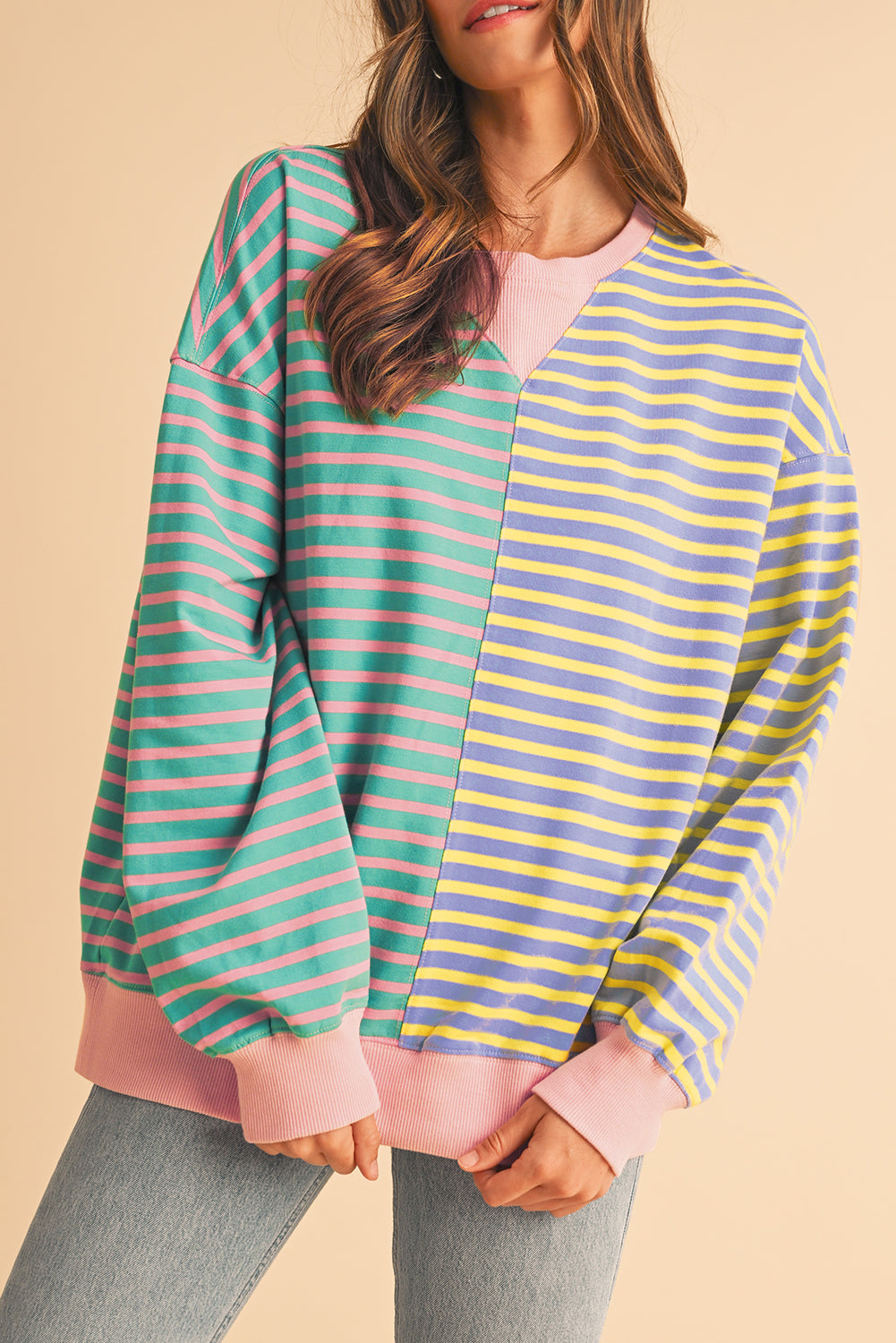 Person wearing a colorful striped shirt with a beige background