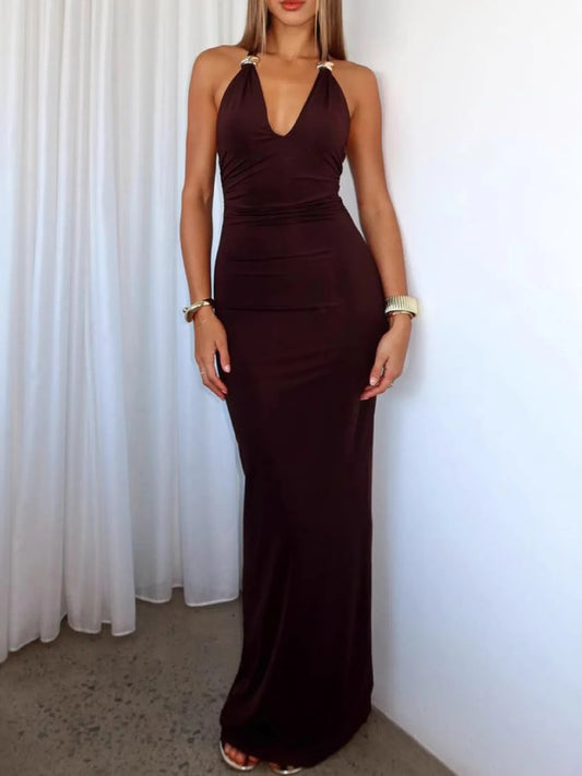 Woman wearing a brown halter neck dress against a white curtain background
