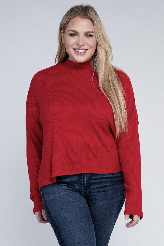Woman wearing a red turtleneck sweater and blue jeans on a white background