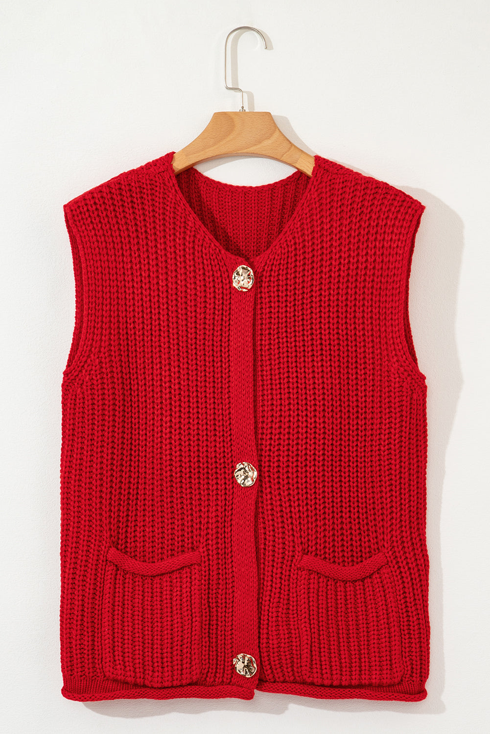 Red knitted vest with buttons on a wooden hanger against a white background