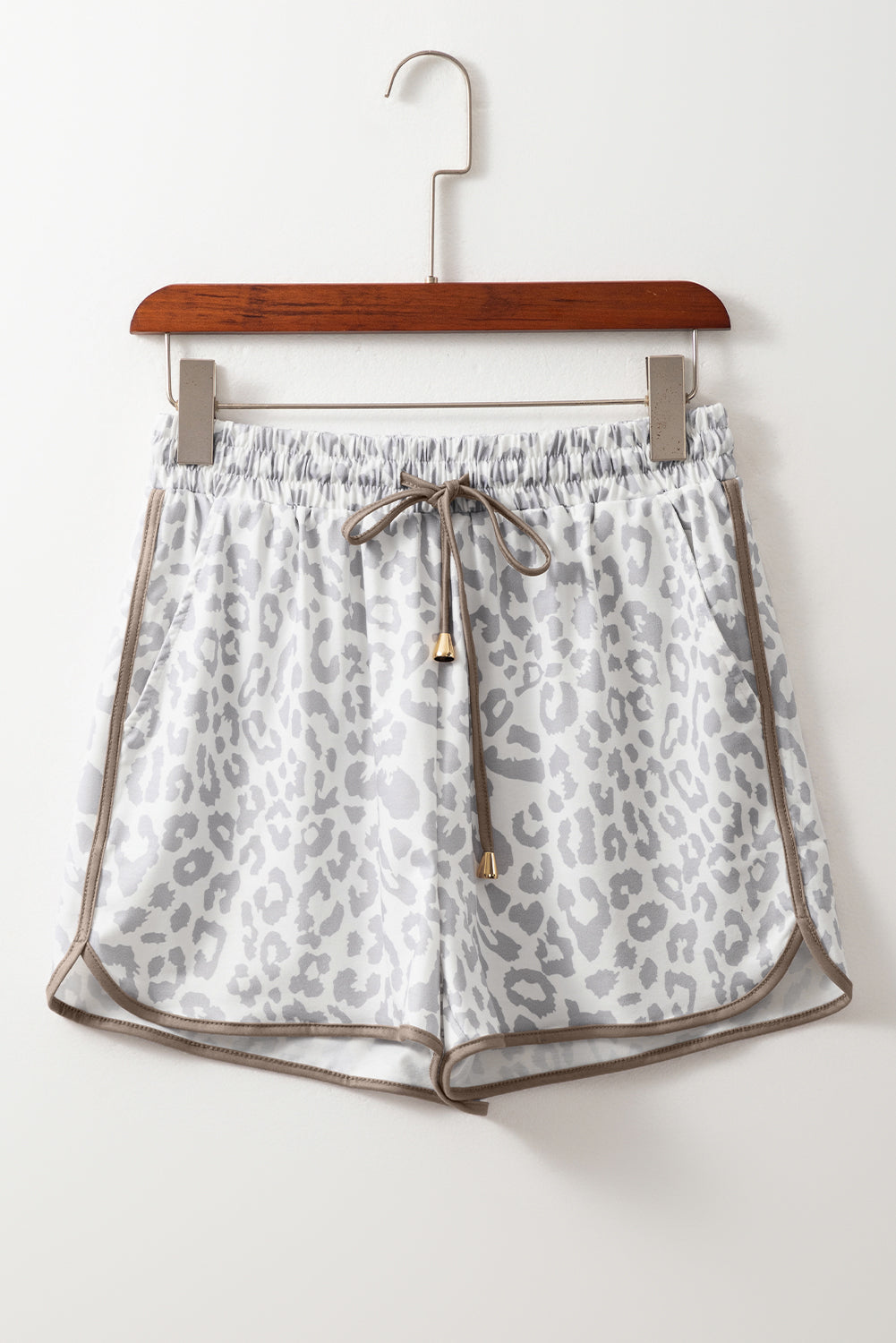 Leopard print shorts on a hanger against a white background