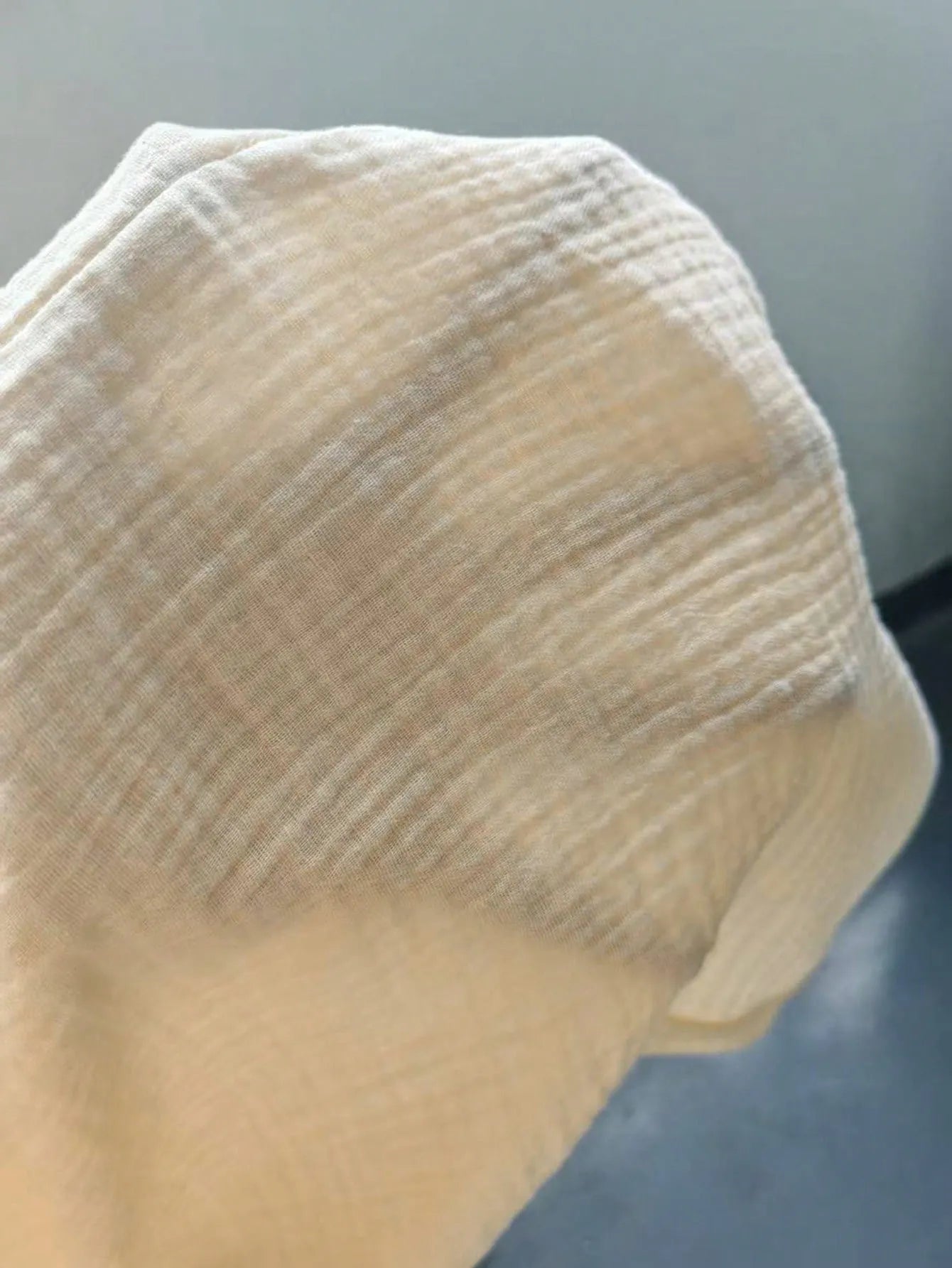 Close-up of a textured beige fabric against a neutral background