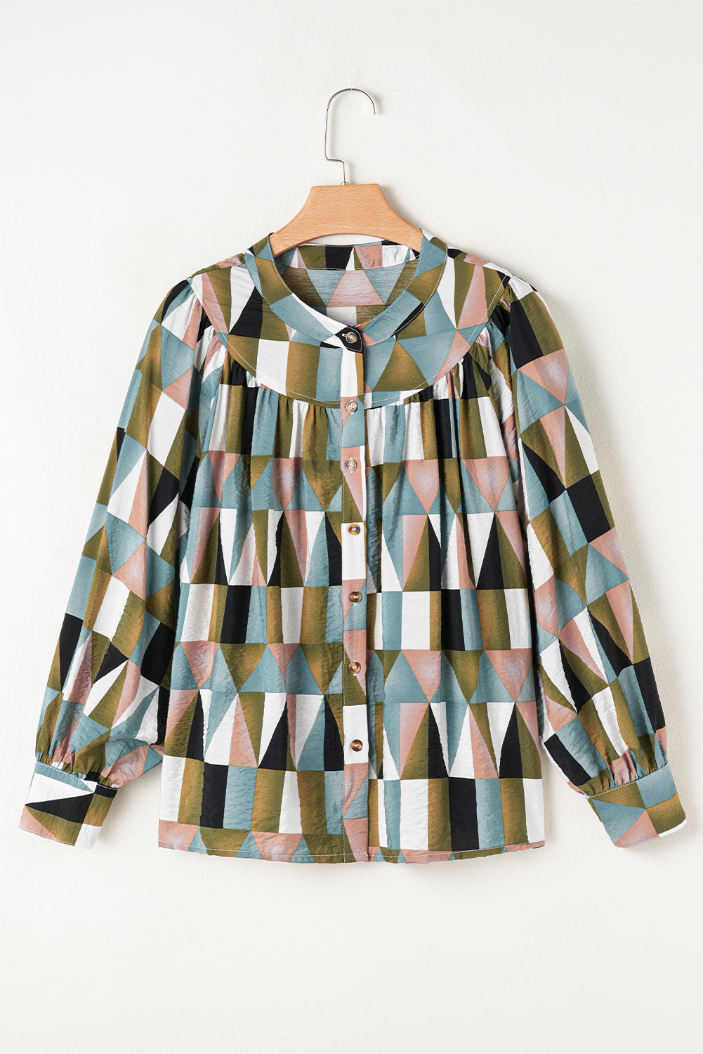 Geometric patterned shirt on a hanger against a white background