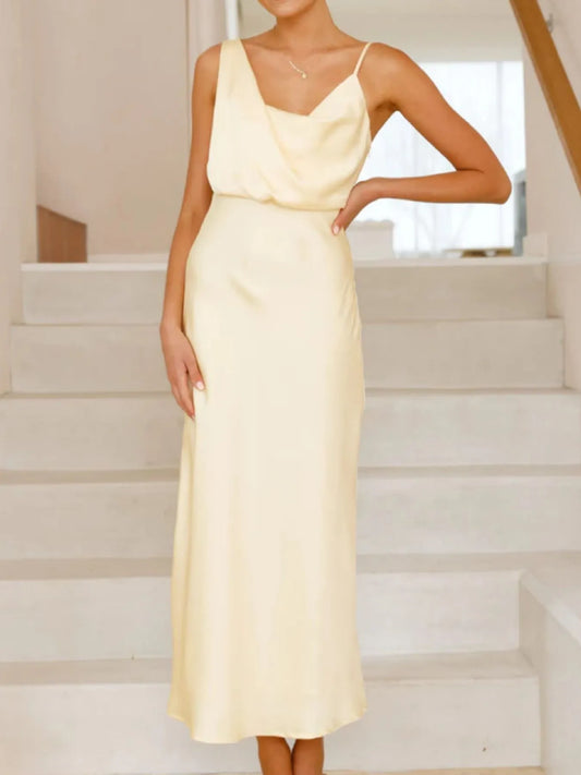 Woman wearing a light yellow dress standing on a staircase.