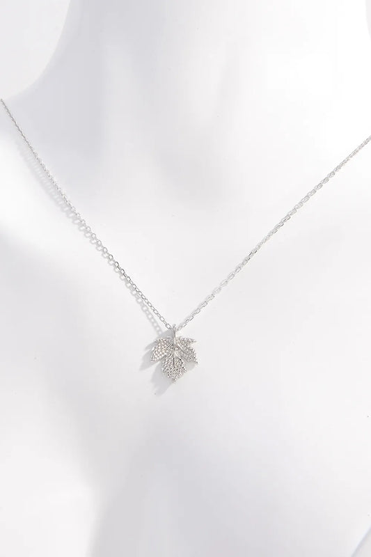 Silver necklace with a leaf pendant on a white background