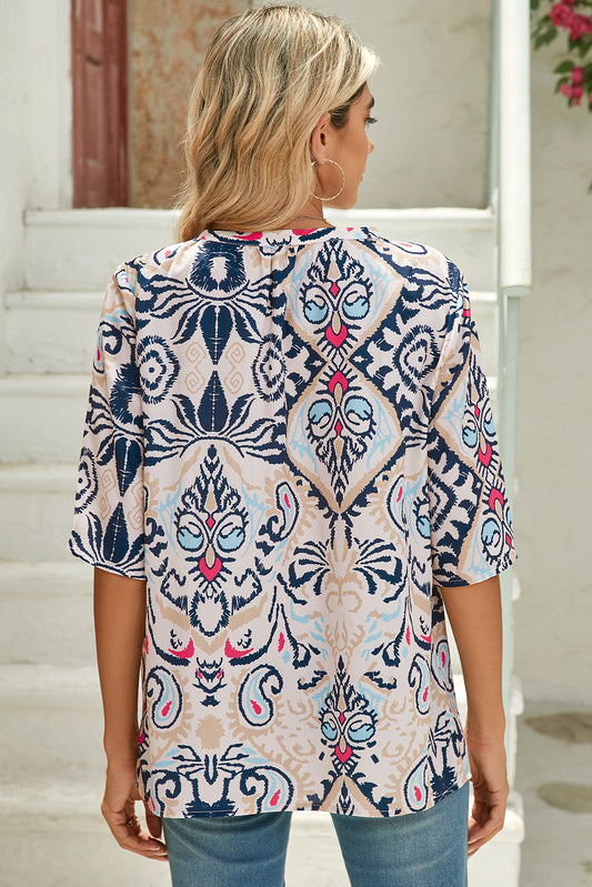 Woman wearing a patterned top with a neutral background
