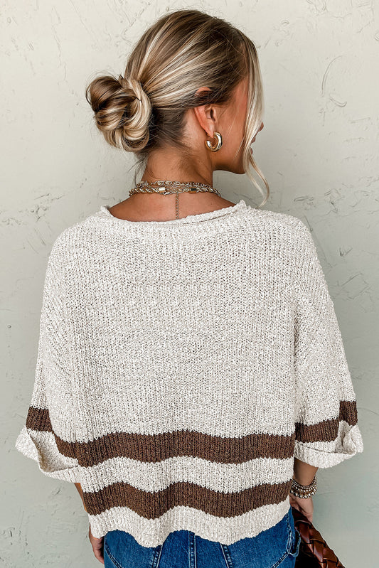Person wearing a beige and brown striped sweater against a neutral background