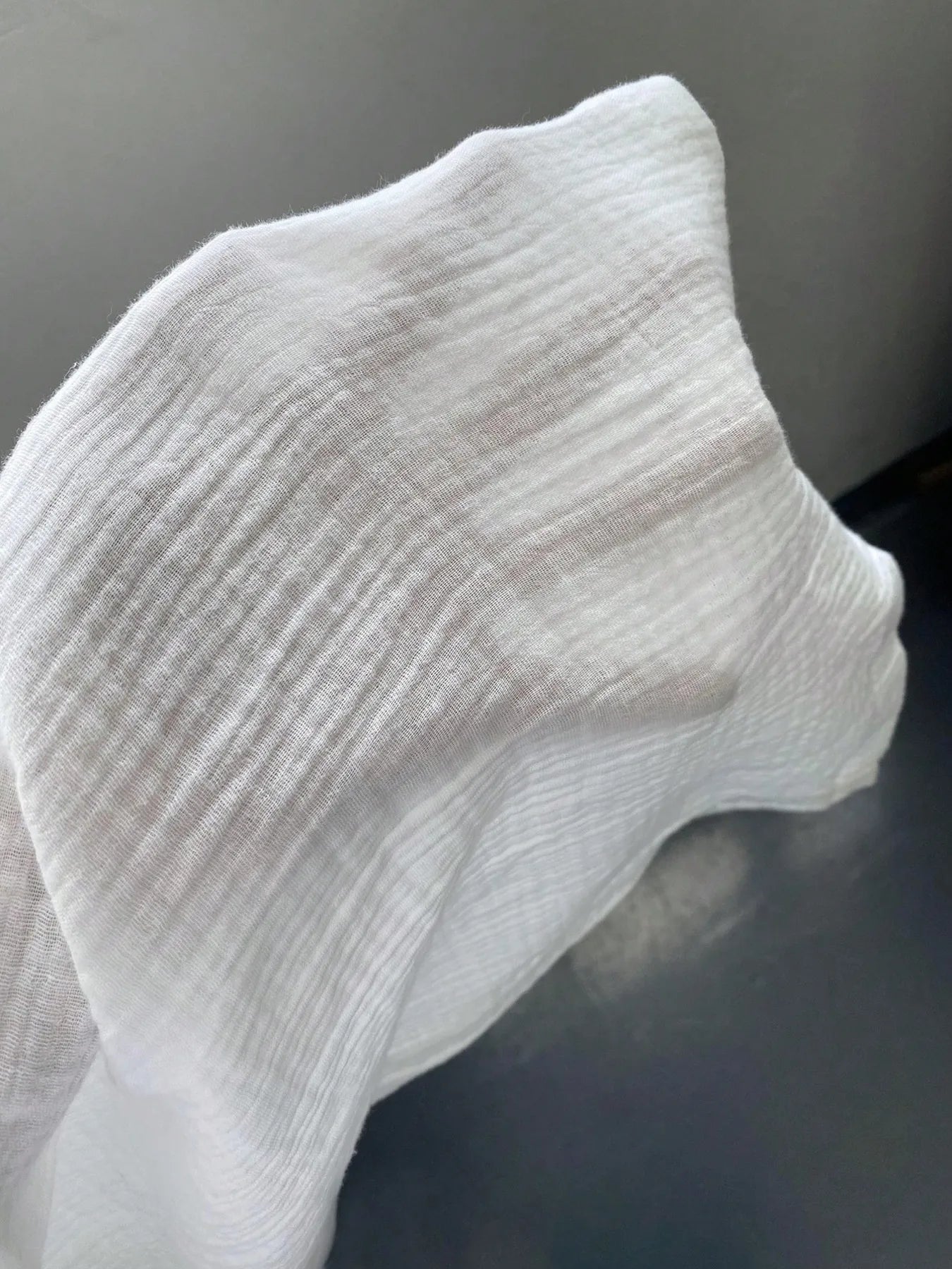 Close-up of a textured white fabric on a dark surface