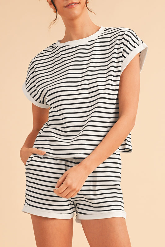 Person wearing a black and white striped outfit on a beige background
