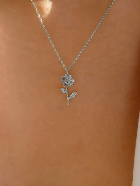 Silver rose necklace on a mannequin with a neutral background