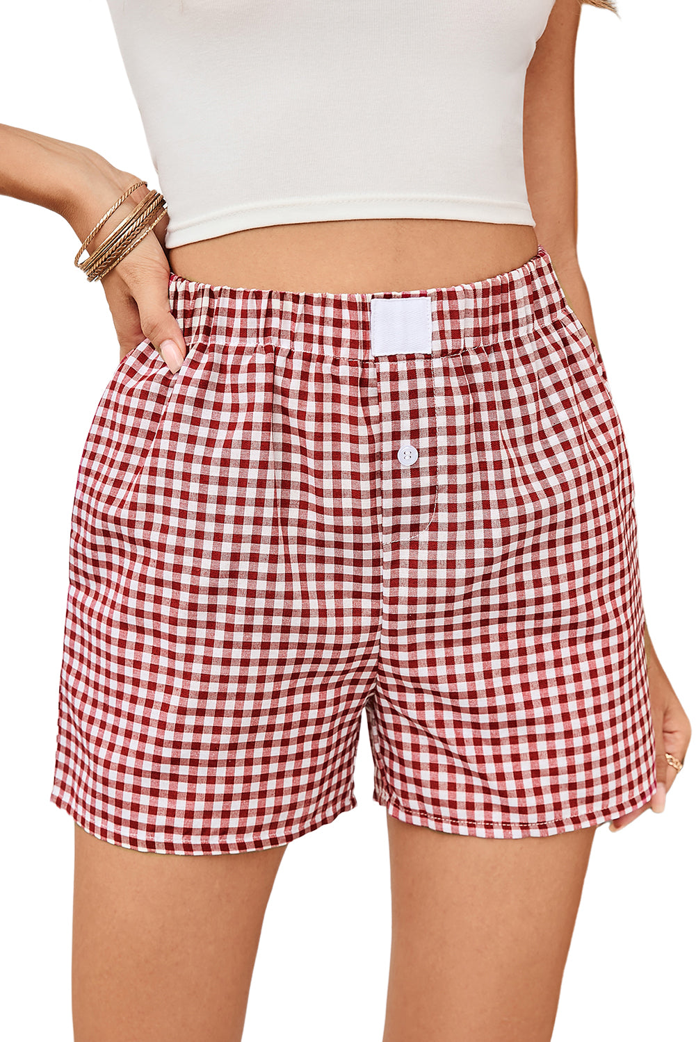 Red and white checkered shorts worn by a person on a plain background