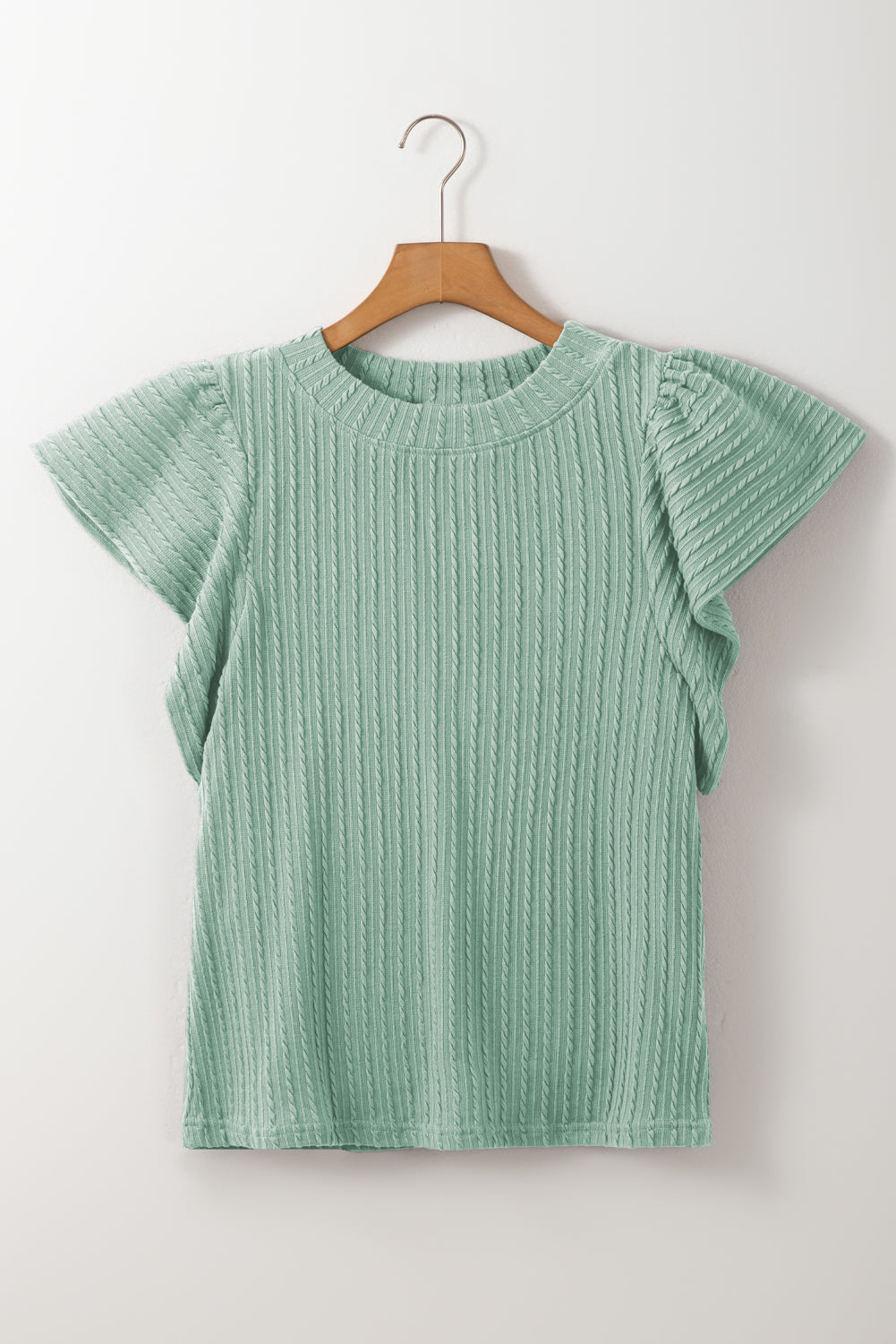 Green textured top on a wooden hanger against a white background
