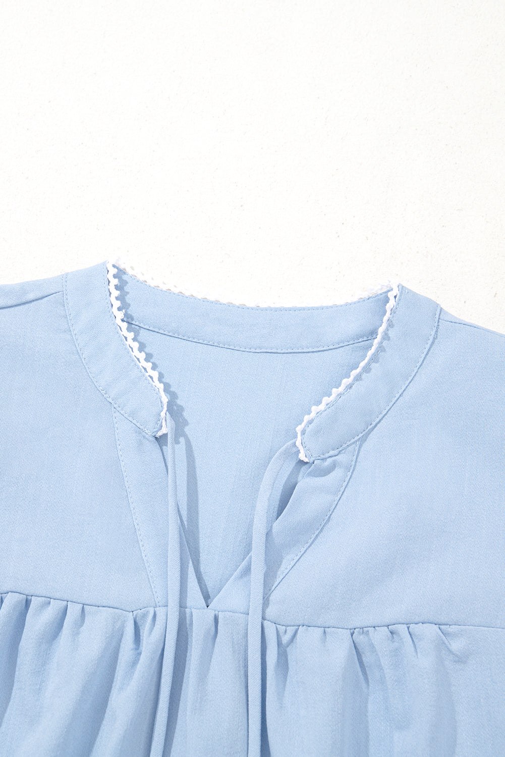 Light blue dress with lace trim on a white background