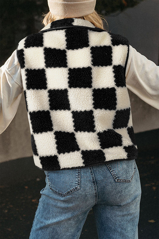 Person wearing a black and white checkered fleece vest with a blurred background