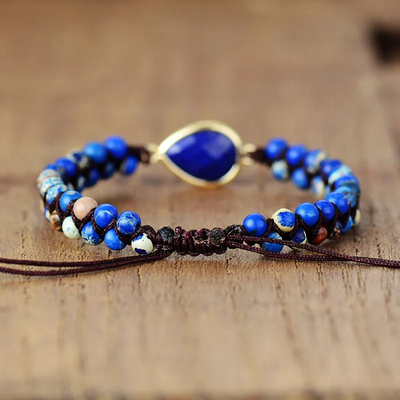 Blue beaded bracelet with a gold accent on a wooden surface