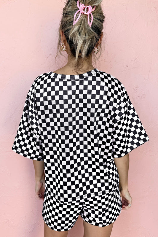 Person wearing a black and white checkered outfit against a pink background