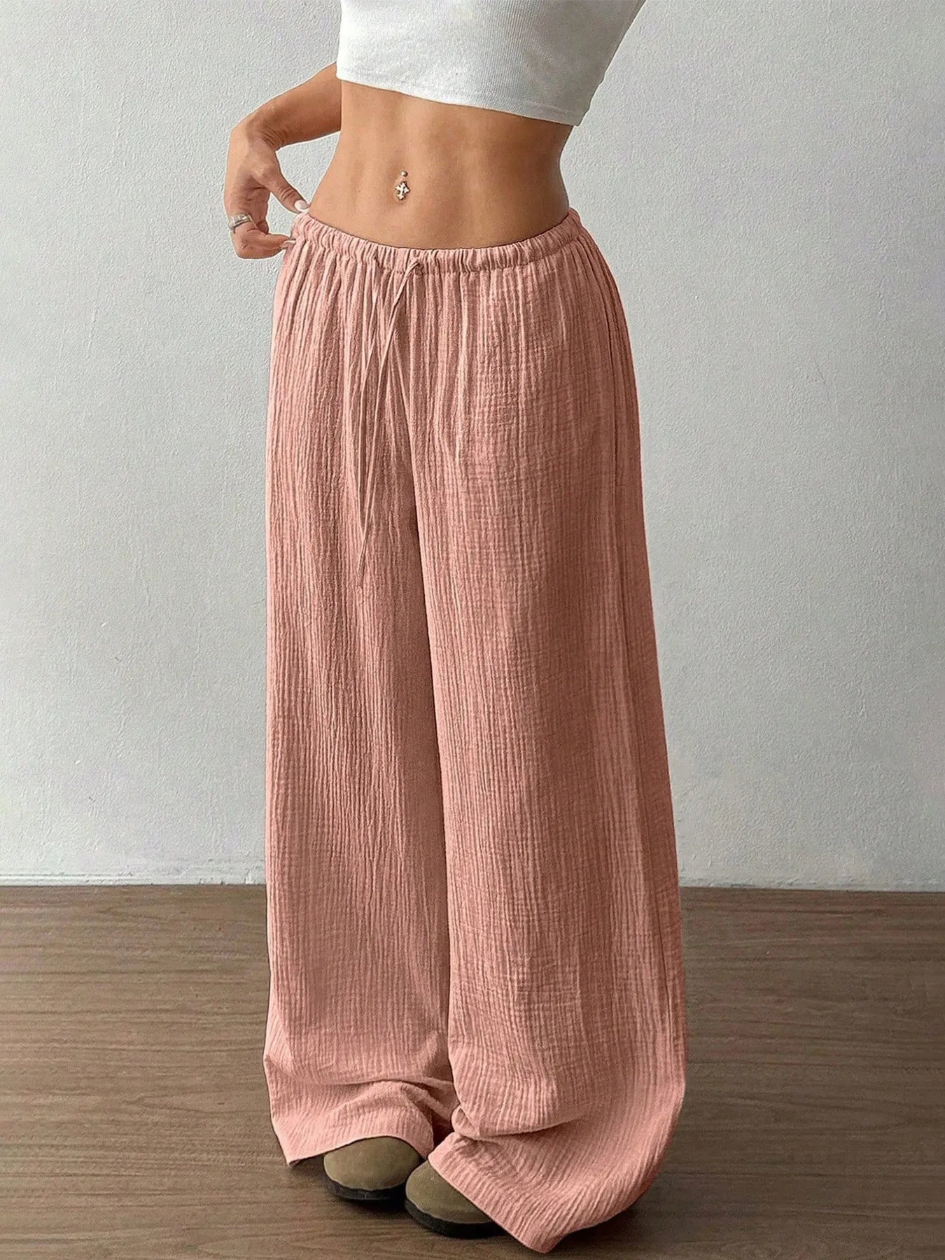 Person wearing pink wide-leg pants against a plain background