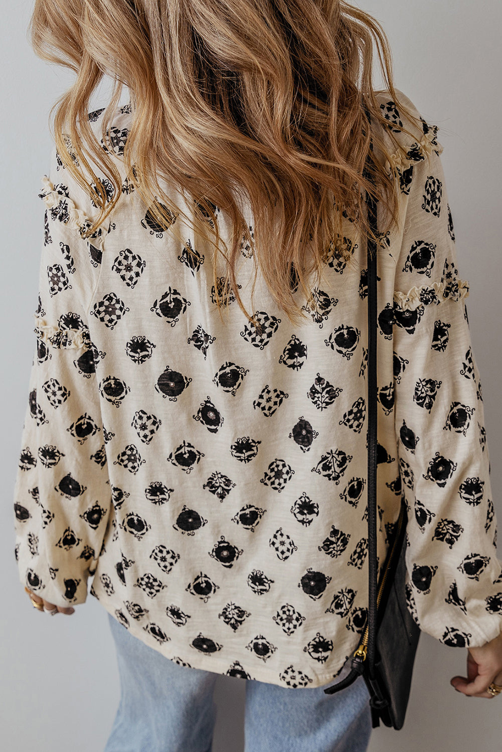 Person wearing a floral blouse with a plain background