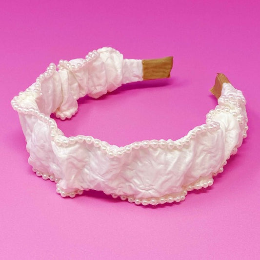 White lace headband on a pink background