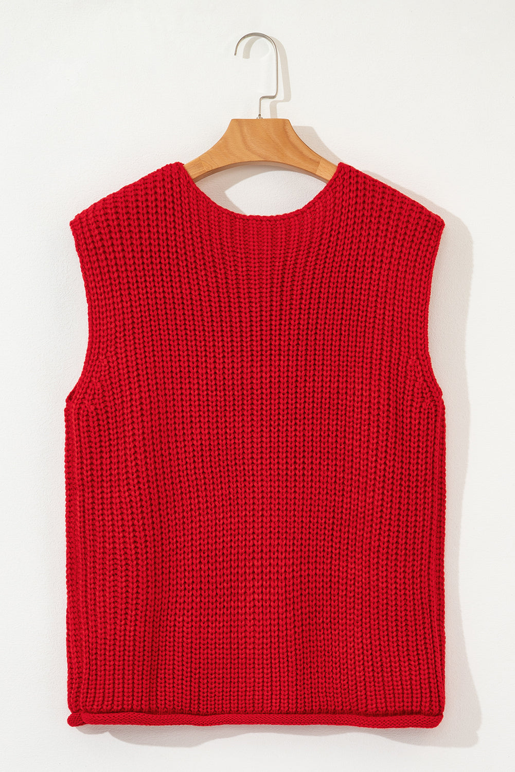 Red knitted vest on a wooden hanger against a white background