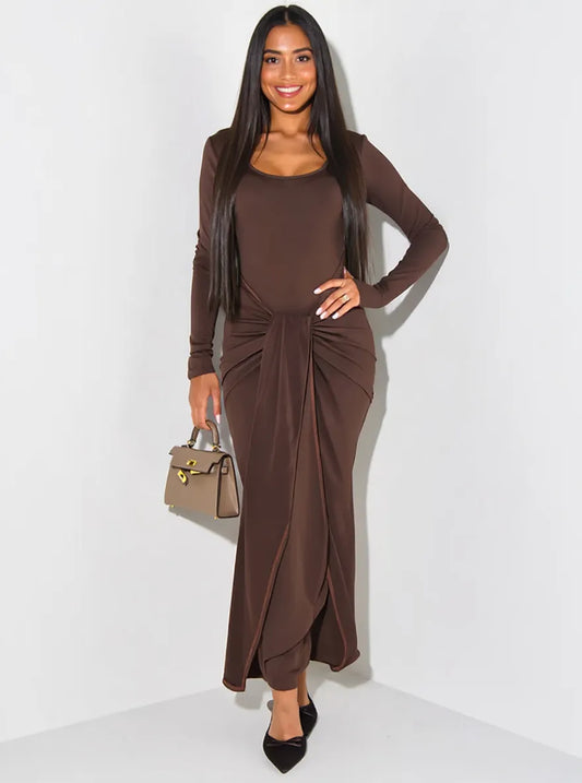 Woman wearing a brown dress with a matching cardigan against a white background