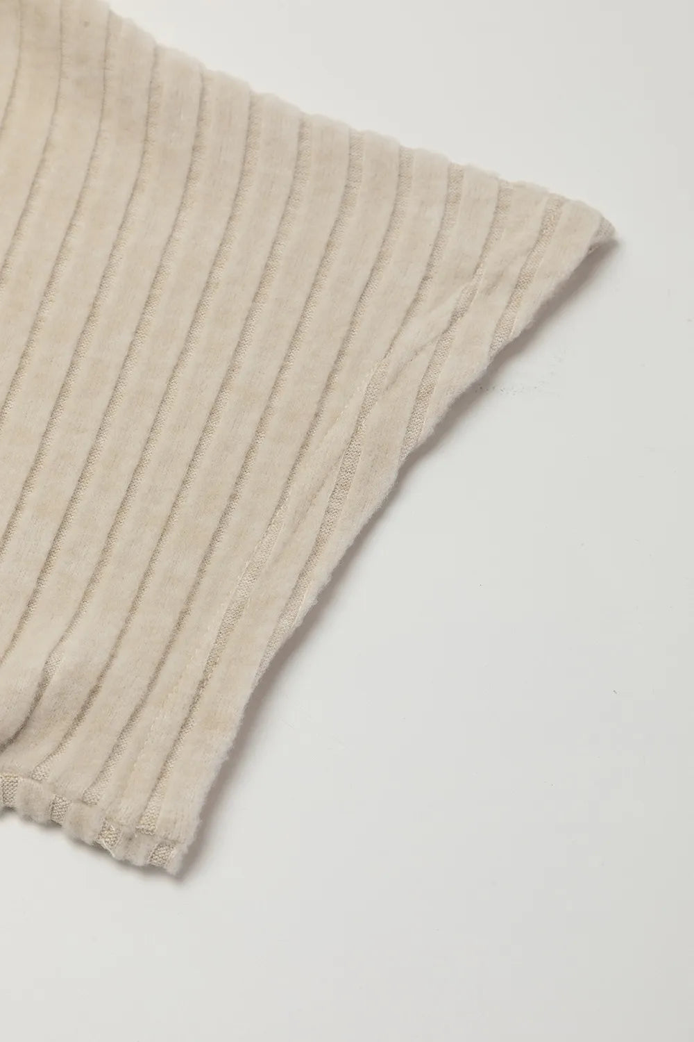 Beige ribbed knit fabric on a white background