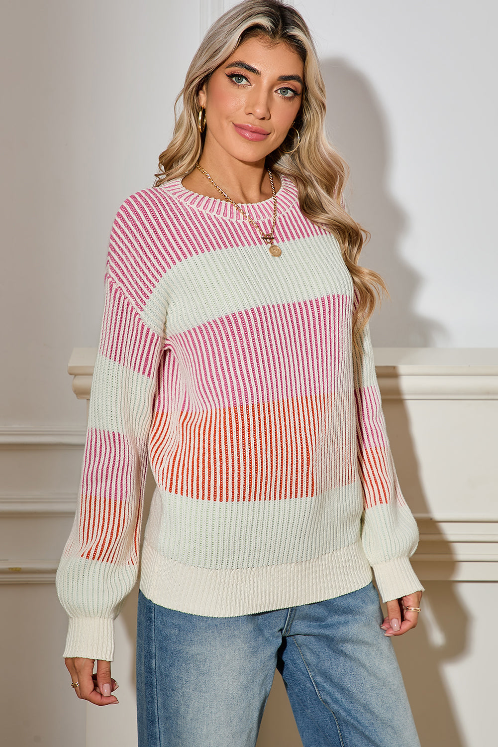 Woman wearing a colorful striped sweater against a neutral background