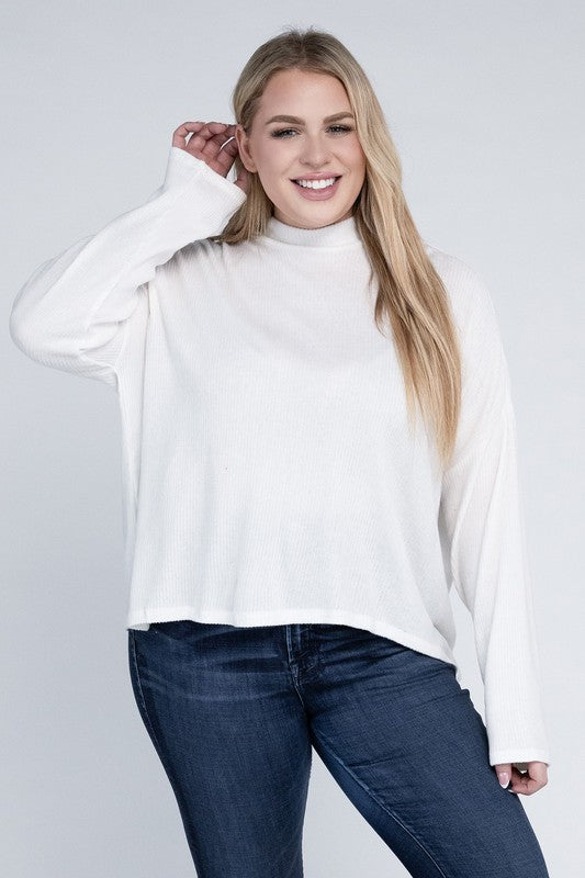 Woman wearing a white turtleneck sweater and blue jeans on a plain background