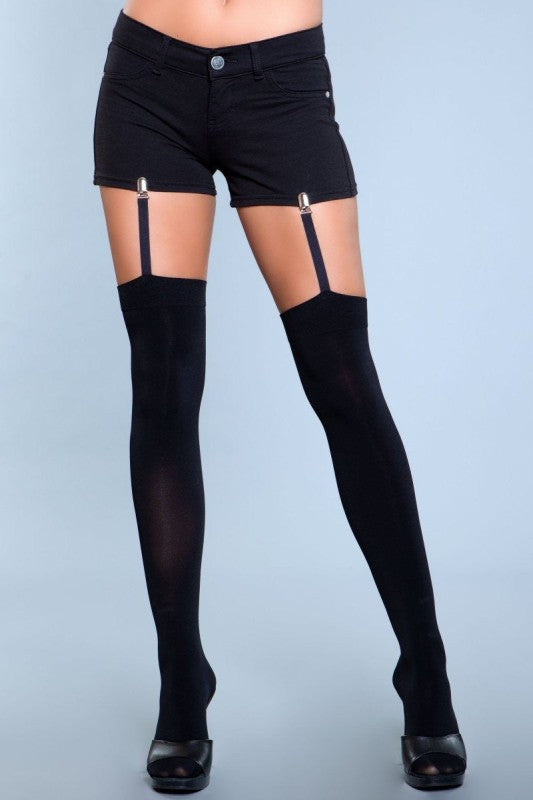 Person wearing black knee-high socks with suspenders on a light blue background