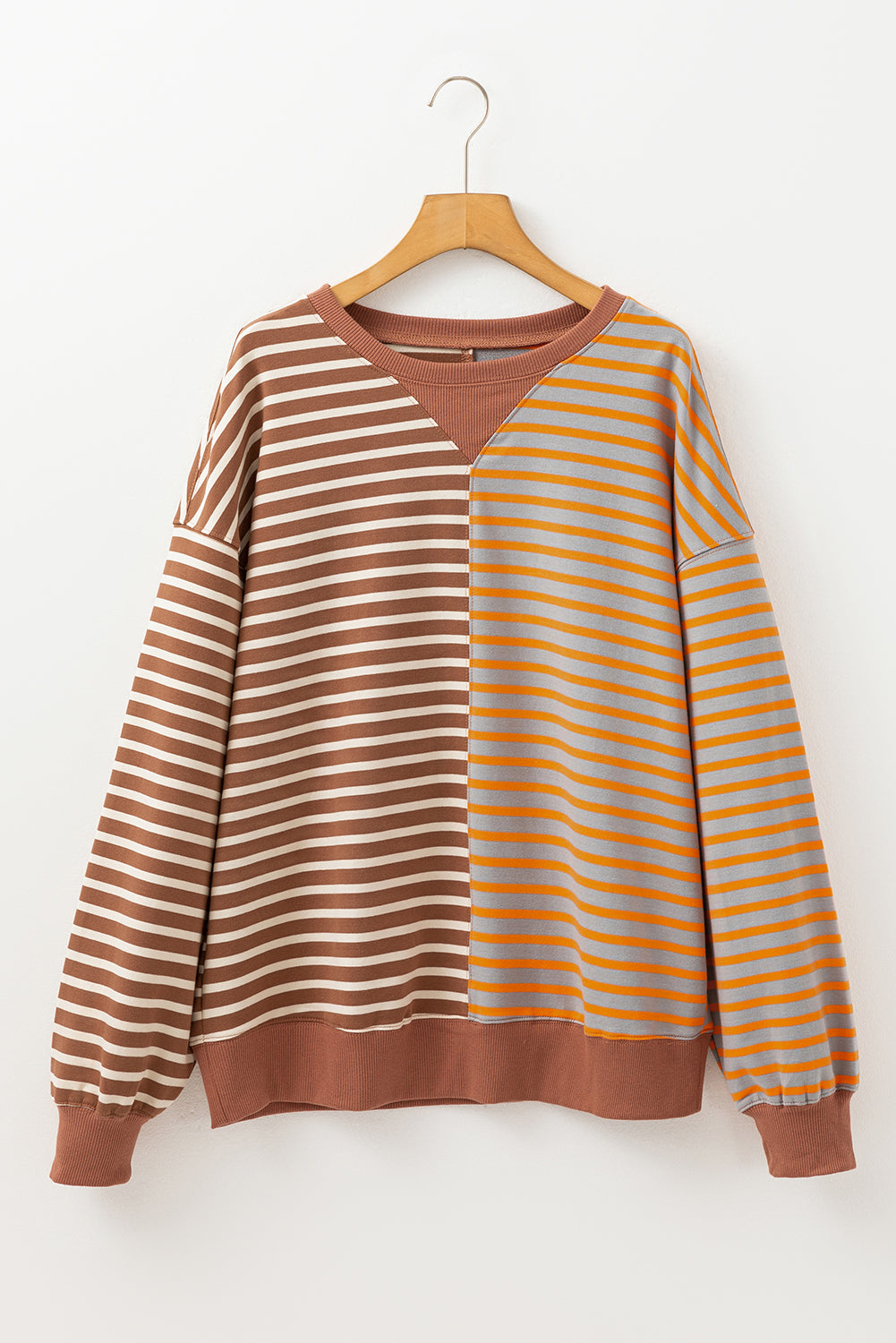 Striped sweater with brown and orange horizontal stripes on a wooden hanger against a white background